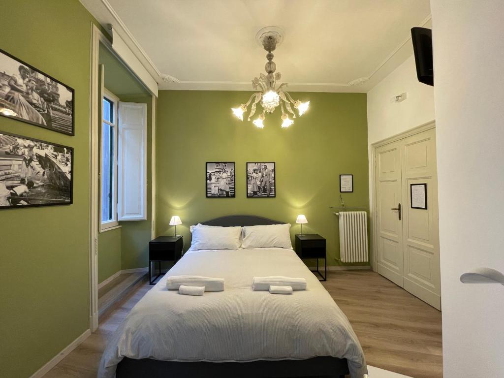 a green bedroom with a bed and a chandelier at Colazione Al Vaticano Guest House in Rome