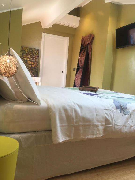 een slaapkamer met een groot bed en een tv aan de muur bij B&B Via Roma 41 in Ventimiglia