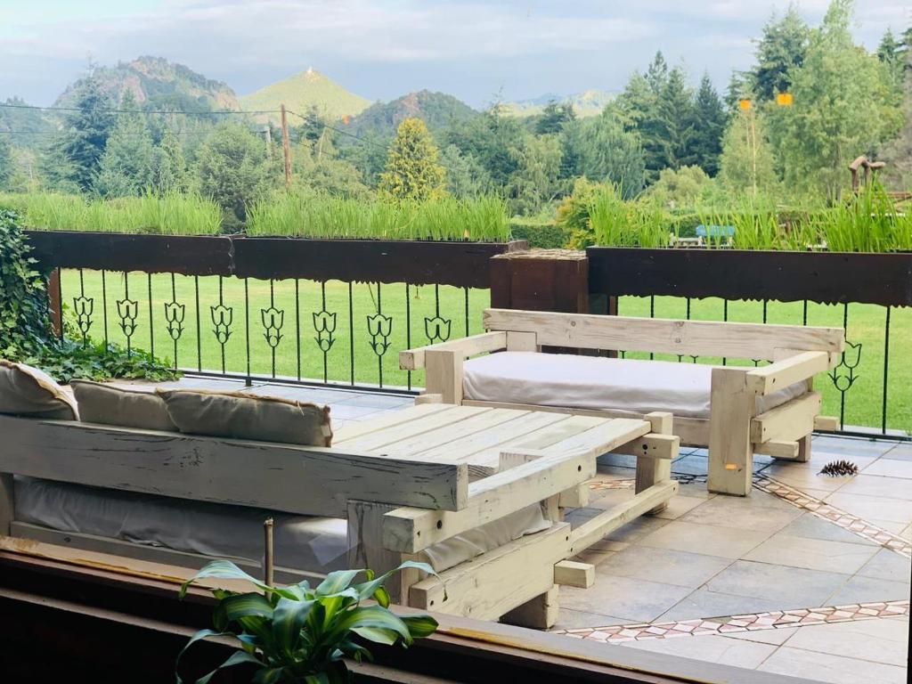 een houten bank bovenop een patio bij Le Bouquet Apart Hotel in Bariloche