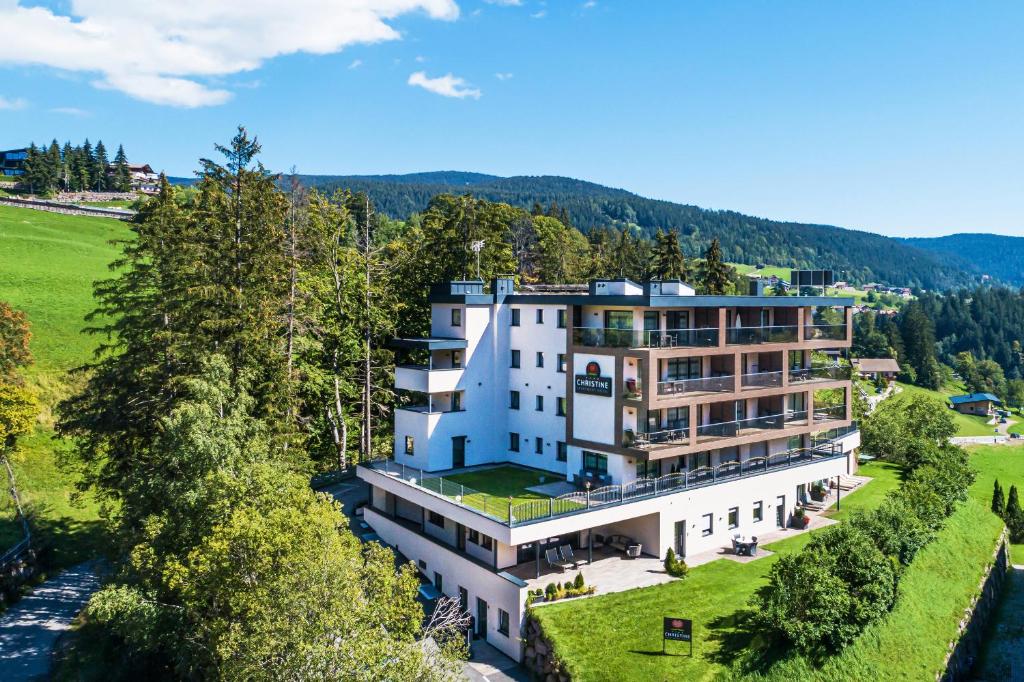 an aerial view of a large white building with trees at Apartment Hotel Christine in Avelengo