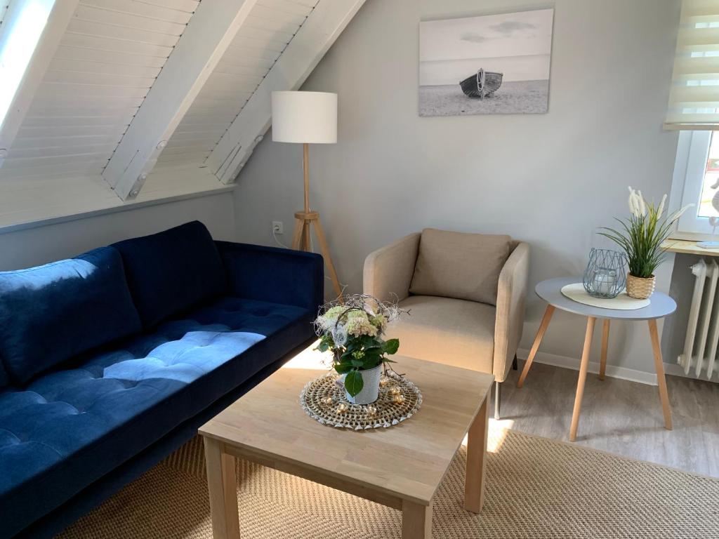 クックスハーフェンにあるNoord Huus Ferienapartmentのリビングルーム(青いソファ、テーブル付)