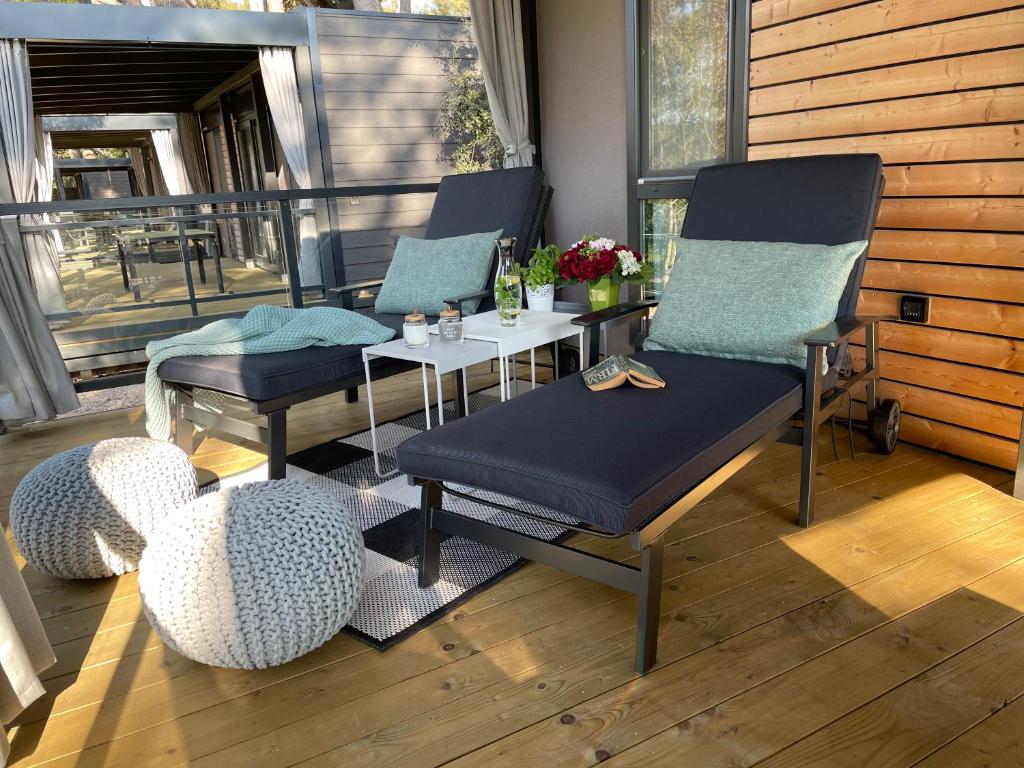 een patio met 3 stoelen en een tafel op een veranda bij ROVINIA mobile home in Rovinj