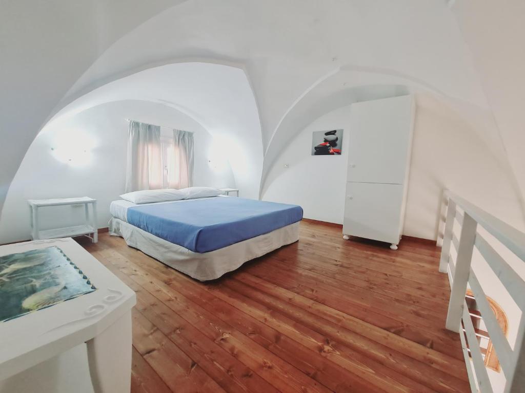 una camera con letto e pavimento in legno di Casa Luce a Porto Cesareo