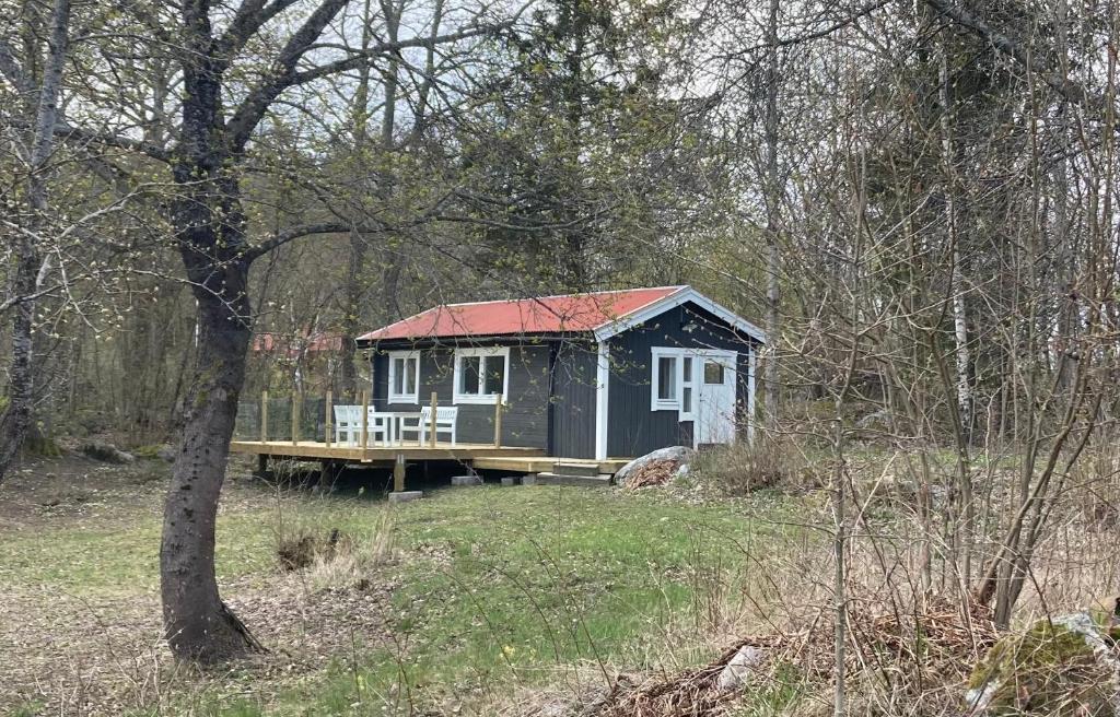 Stallarholmen的住宿－Sjövillan 2，树林中的一个红色屋顶的小小屋