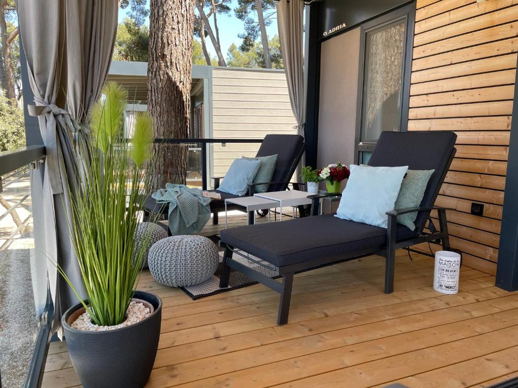 een patio met 2 stoelen, een tafel en planten bij HARMONIA mobile home in Rovinj