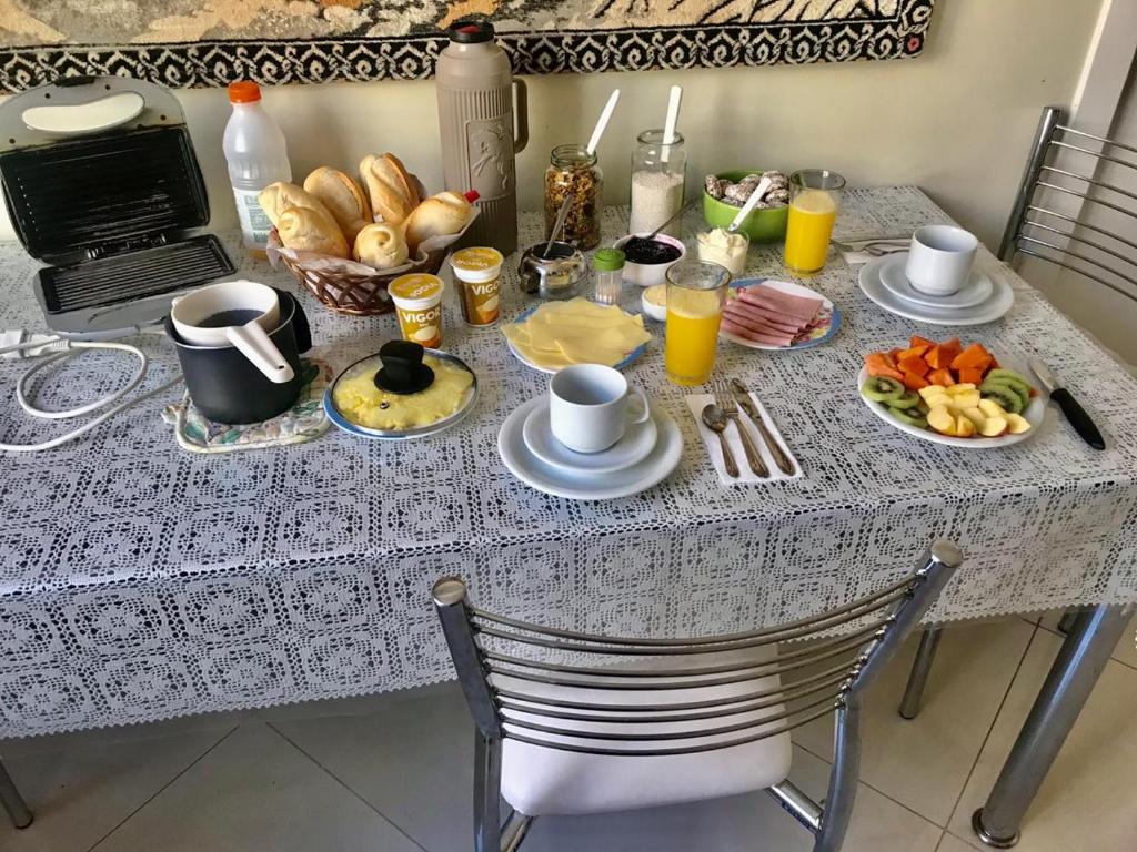 a breakfast table with food and a laptop on it at HomeStay 3 - Avenida Carlos Gomes in Porto Alegre