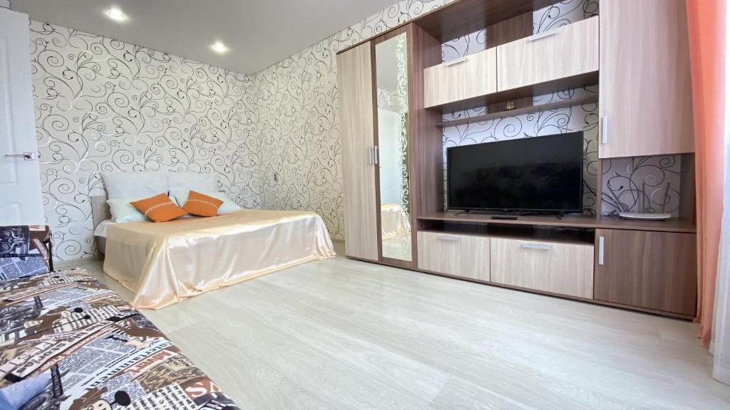 a bedroom with a bed and a flat screen tv at Right Room на Братьев Луканиных in Kaluga