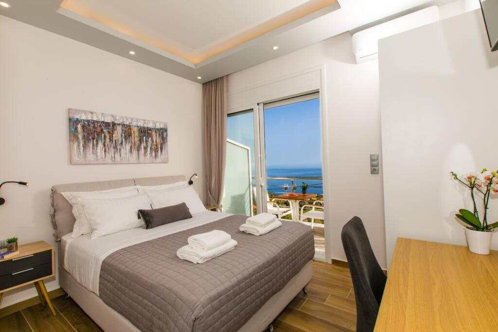 1 dormitorio con cama, mesa de comedor y ventana en Chrysi's Ocean View Retreat en Kerames