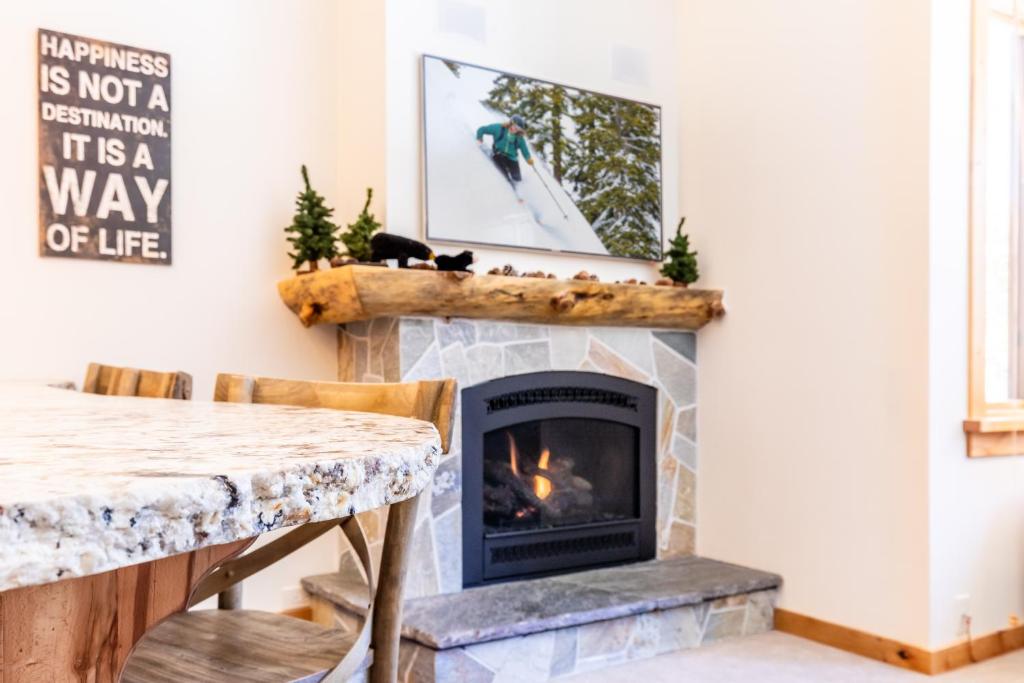 - un salon avec une cheminée et une table dans l'établissement Beautiful Mountain 2 Bedroom Ski-In Ski-Out in Ski Trails condo, à Kingswood Estates