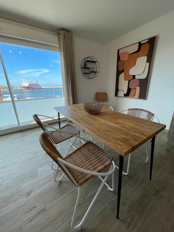 a dining room table with chairs and a large window at Residence Des Îles in LʼÎle-Rousse