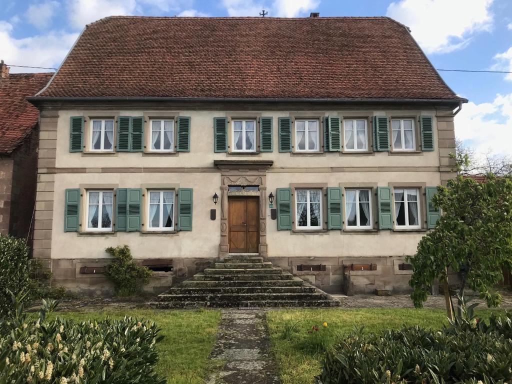 uma casa velha com persianas verdes e uma porta em Maison Zielinger em Petersbach