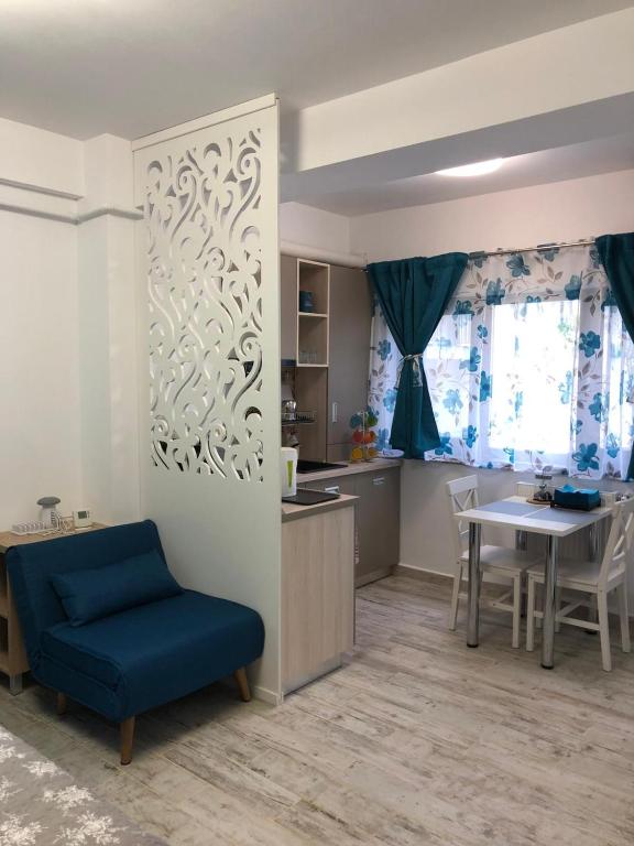 a living room with a blue chair and a table at Studio Turquoise - Eforie Nord in Eforie Nord