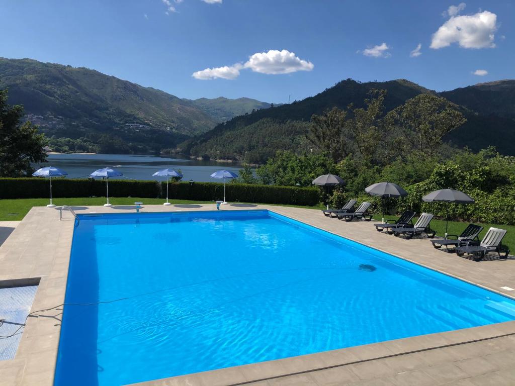 una piscina con vistas al lago y a las montañas en Hotel Eco Salvador, en Gerês