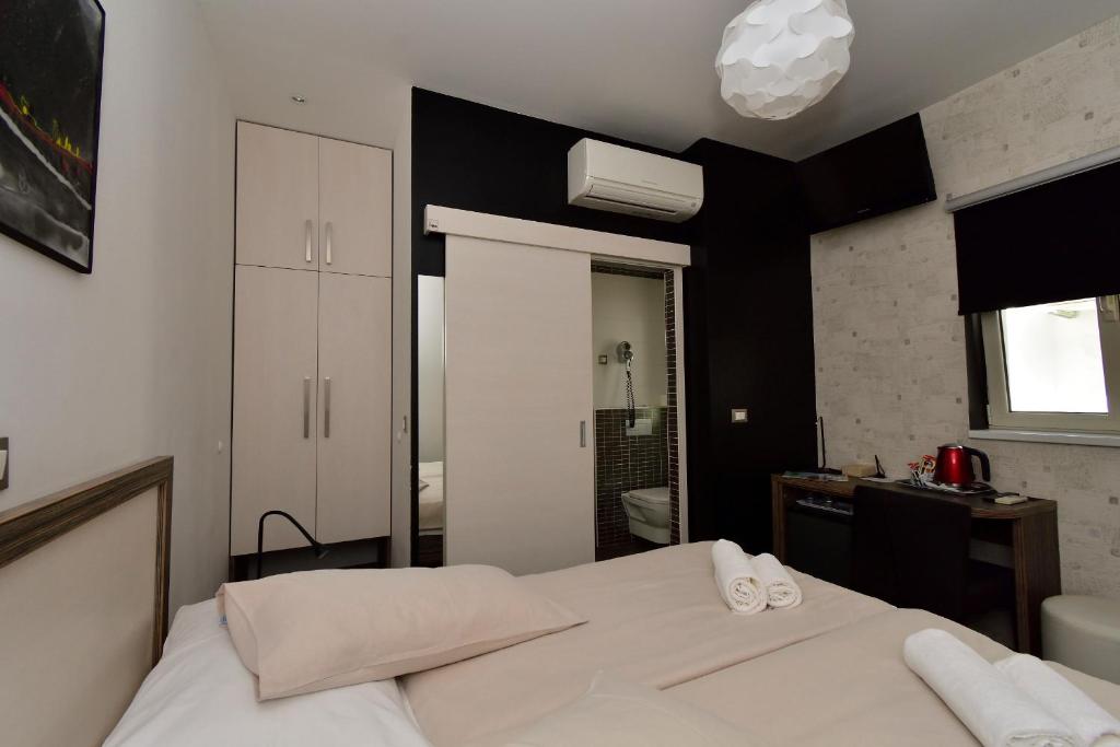 a bedroom with a white bed and a bathroom at Marmontova Luxury Rooms in Split