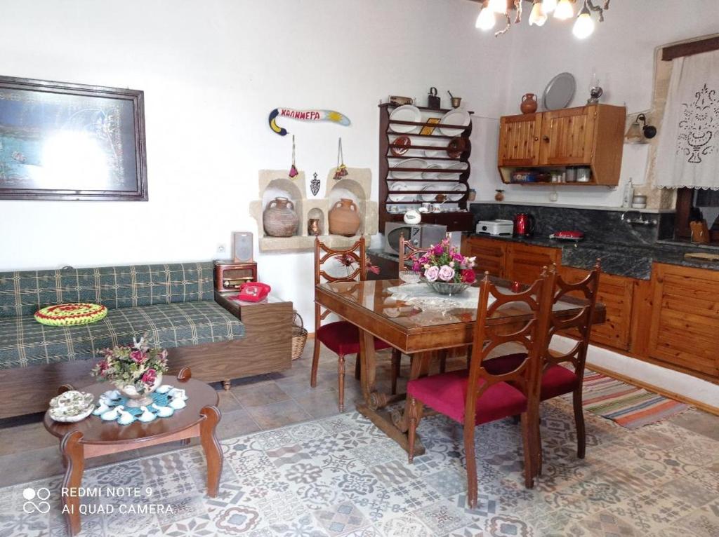 a living room with a table and chairs and a couch at TRADITIONAL HOUSE MARIA in Azoyirás