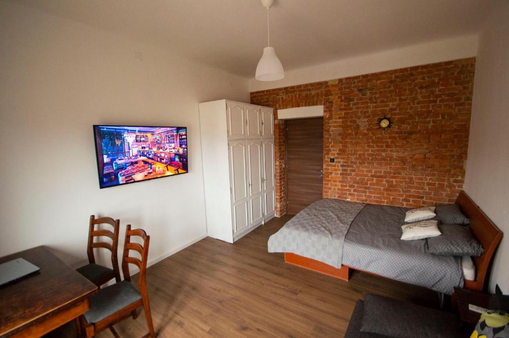 een slaapkamer met een bed en een tv aan de muur bij Rijeka city rooms in Rijeka