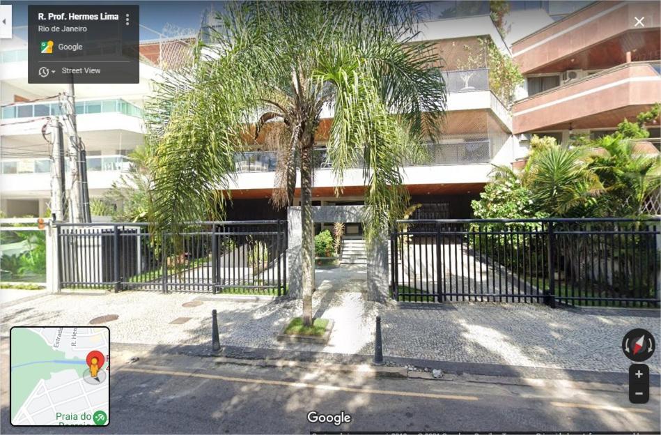 una recinzione con un albero di fronte a un edificio di Recreio, a praia mais charmosa do RJ! a Rio de Janeiro