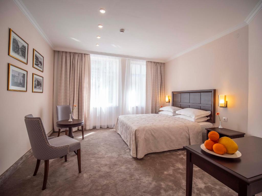 una camera d'albergo con un letto e un tavolo con frutta su un tavolo di The Moon Boutique Hotel a Sofia