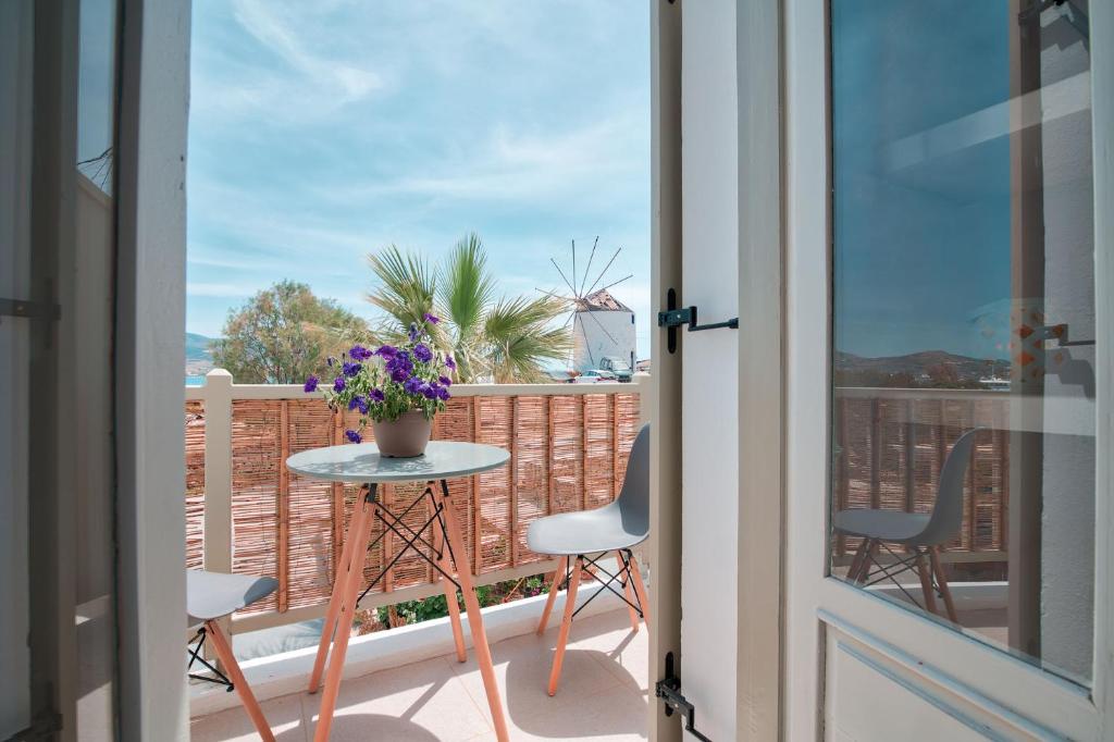 a balcony with a table and chairs and a window at Meltemi Antiparos in Antiparos