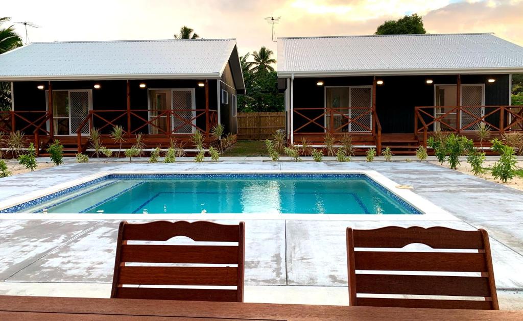 a swimming pool in front of a house at Palm Tree Villas in Rarotonga