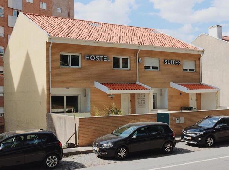 dois carros estacionados num parque de estacionamento em frente a um hotel em Oportocean Hostel em Matosinhos
