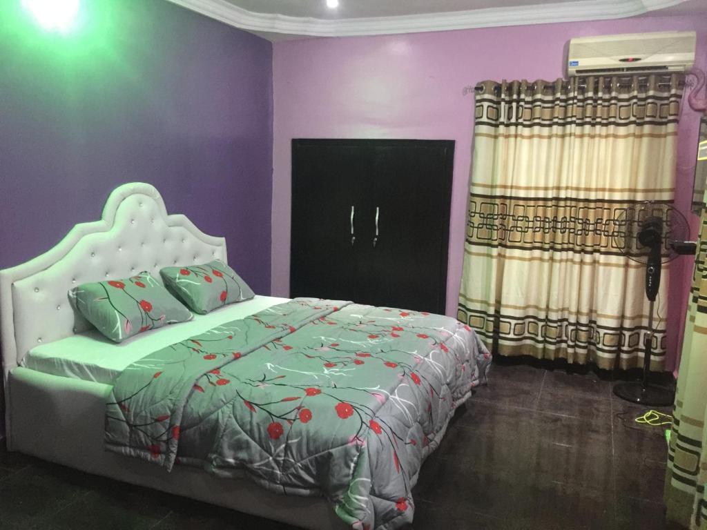 a bedroom with a bed and a purple wall at Juicebox B&B in Lagos