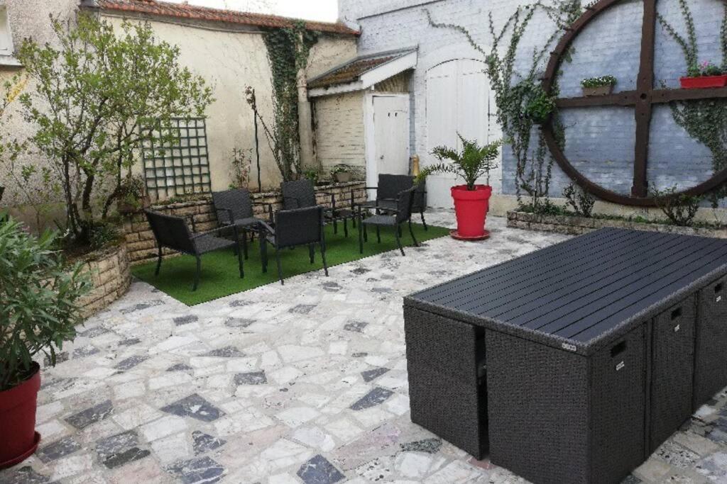 een patio met stoelen en tafels en een tafel en stoelen bij Gîte« Le Pressoir » chez viticulteur en biodynamie in Avenay-Val-dʼOr