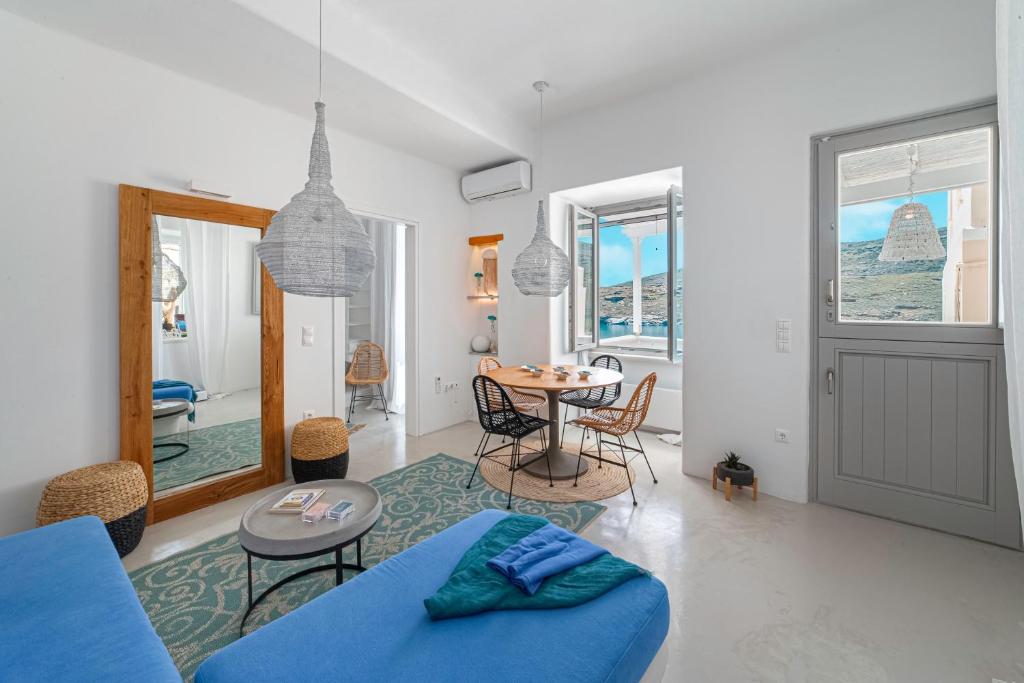 Lasia Boutique Apartment في آنذروس: غرفة معيشة مع أريكة زرقاء وطاولة