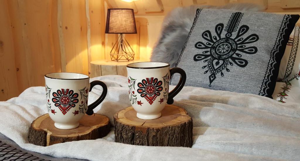 two coffee mugs sitting on top of a bed at VILLA JAGODOVO Biały Dunajec in Biały Dunajec