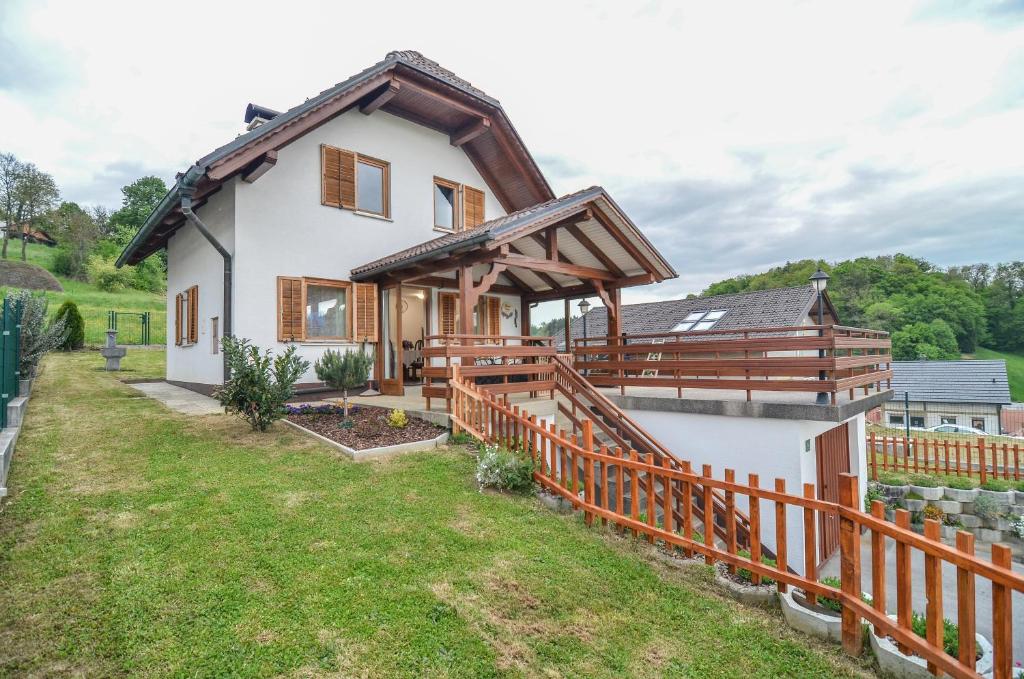 une maison avec une clôture en bois devant elle dans l'établissement Flower house Podčetrtek, à Podčetrtek