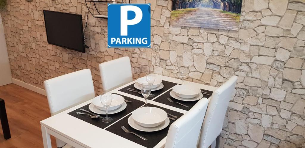 een eetkamer met een witte tafel en witte stoelen bij Apartamento EL CARMEN con Parking GRATIS in Toledo