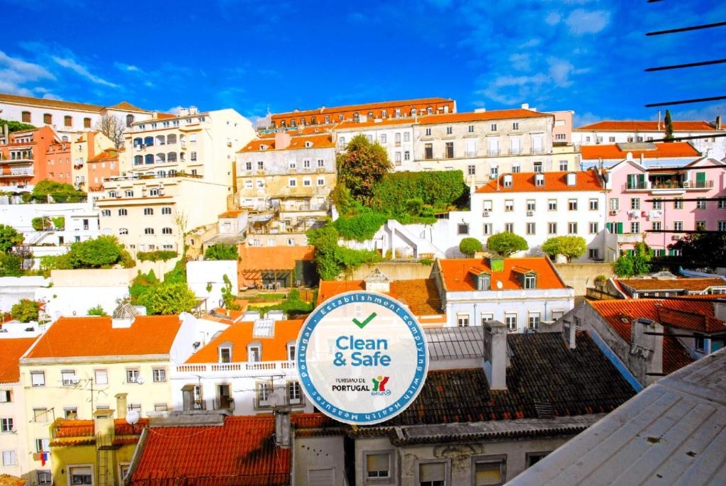 リスボンにあるホステル ドゥ カステロ リスボアの手前の看板を持つ市街の景色