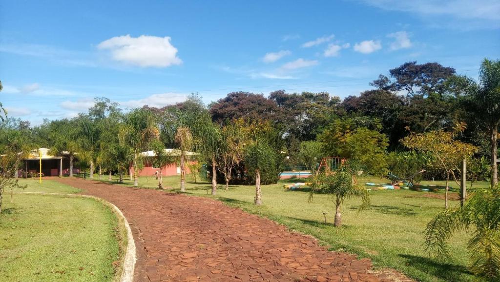 un camino de tierra en un campo con árboles en el fondo en Pousada Chácara Mamma Gaia, en Foz do Iguaçu