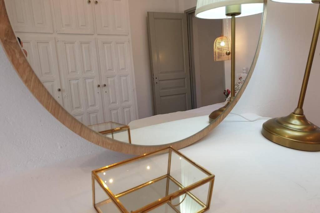 a mirror sitting on a table with a gold lamp at Patmos Little Suites in Skala