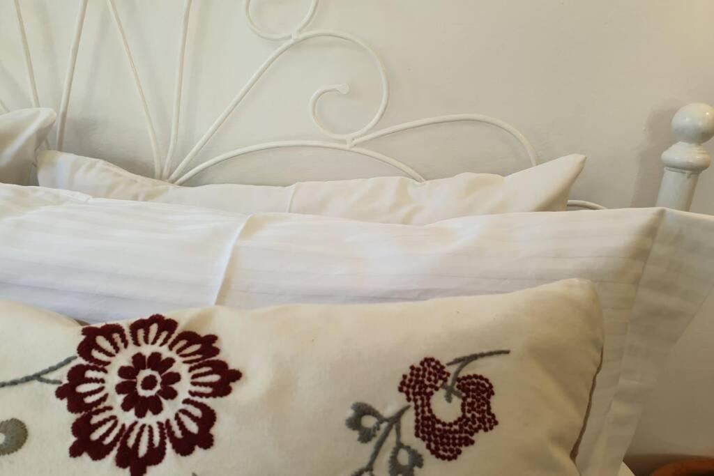 a white bed with white pillows and a white headboard at Patmos Little Suites in Skala