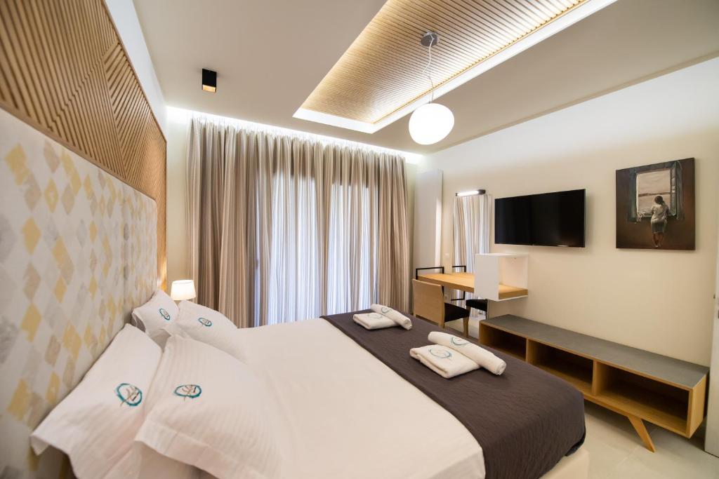 Pokój hotelowy z dużym łóżkiem i biurkiem w obiekcie Aelia Suites w mieście Áyios Pétros