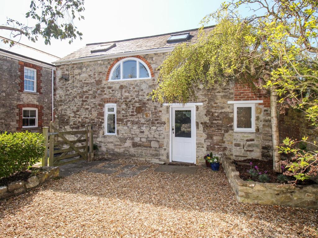 a brick house with a white door and a fence at Little Brook in Broadwey