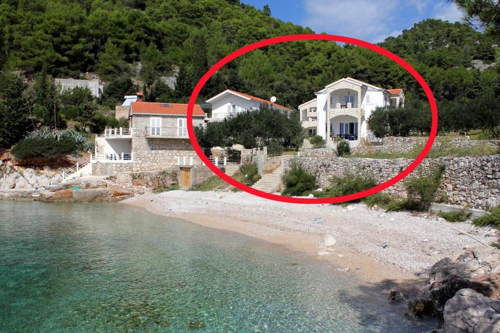 a house on a beach with a red circle at Seaside secluded apartments Cove Jedra, Hvar - 2583 in Gdinj