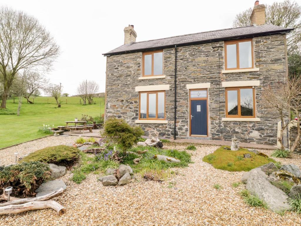 a stone cottage with a garden in front of it at Groes Lwyd in Gwyddelwern
