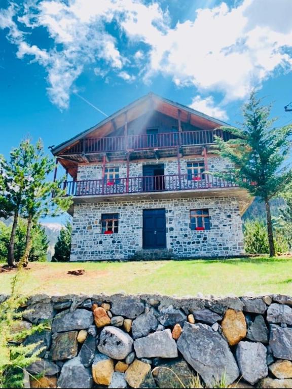 a stone house with a stone wall in front of it at Hotel Grabova in Grabova e Sipërme