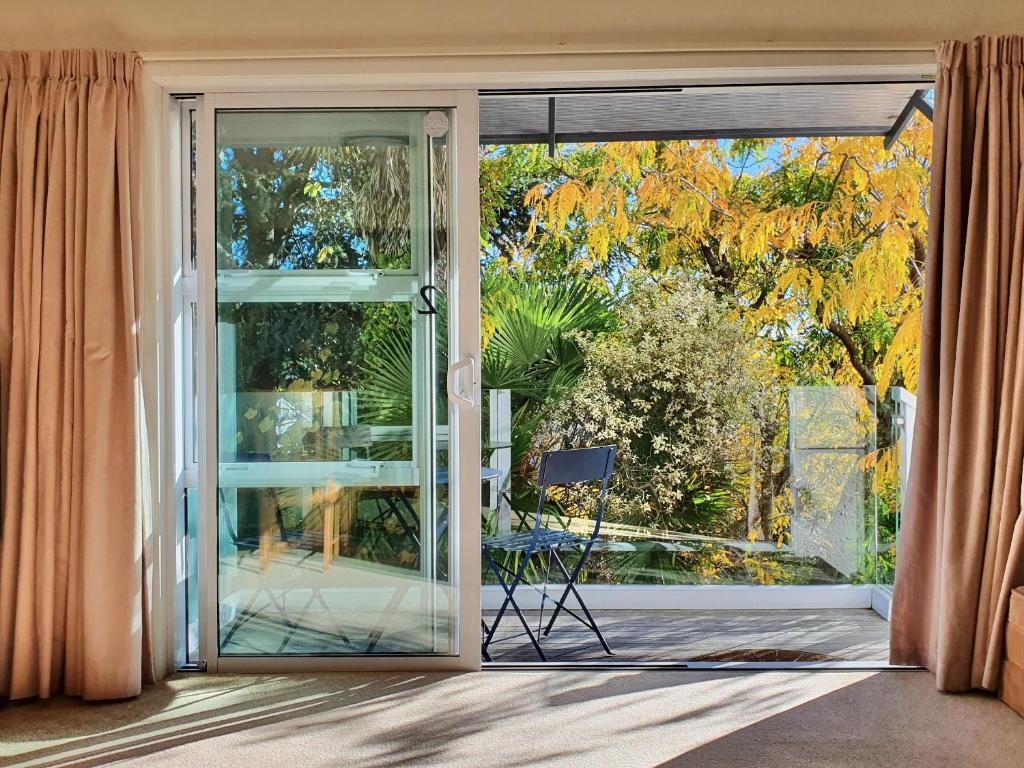 uma porta de vidro deslizante aberta com vista para um pátio em Kimberley Two - Nelson Waterfront Apartment em Nelson