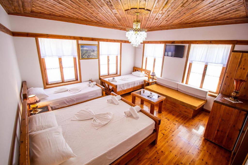 1 dormitorio con 2 camas y lámpara de araña en Hotel Bebej Tradicional en Gjirokastër