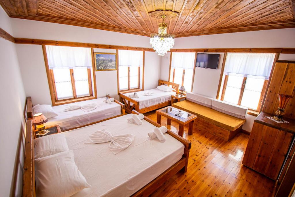 a bedroom with two beds and a chandelier at Hotel Bebej Tradicional in Gjirokastër