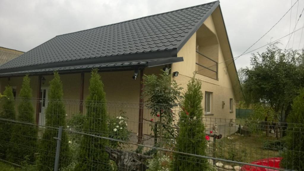 uma casa com um telhado preto e uma cerca em Casa Mamei em Suceava