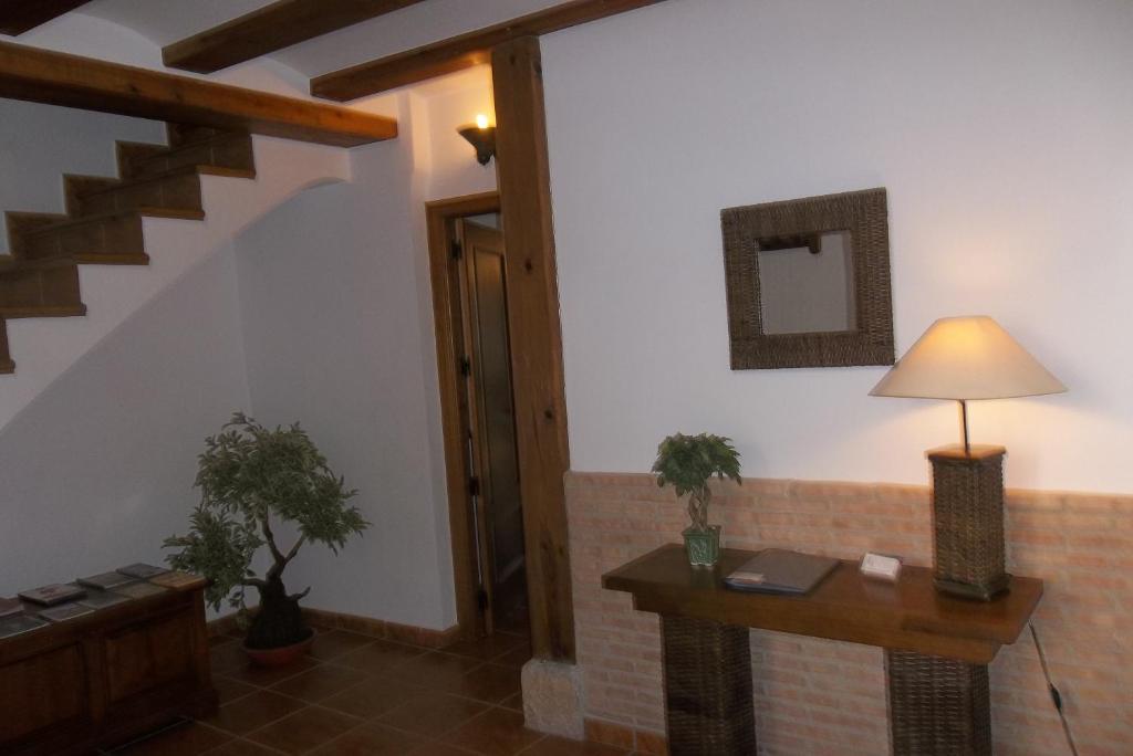 a living room with a table and a lamp at Casa Rural El Temple in Las Cuevas de Cañart