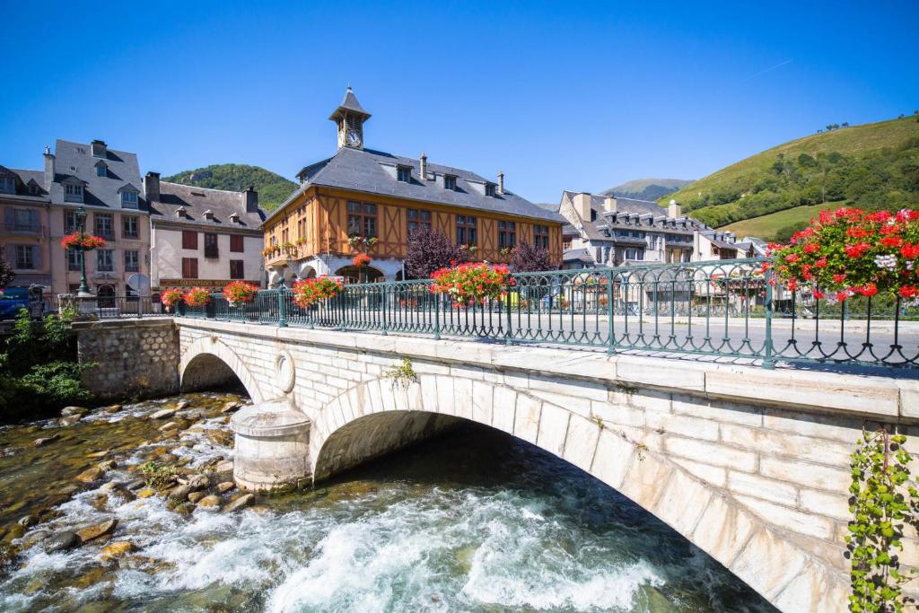 un puente de piedra sobre un río en una ciudad en Entre Montagne et Rivière, en Arreau