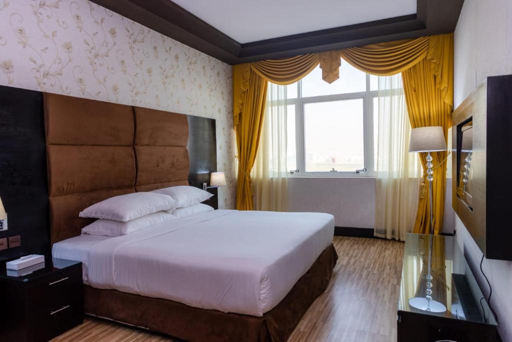 a bedroom with a large bed and a window at Mangrove Hotel in Ras al Khaimah