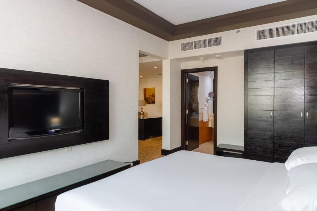 a bedroom with a flat screen tv on a wall at Mangrove Hotel in Ras al Khaimah