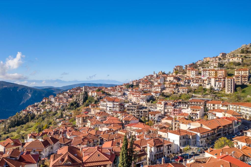 a town on a hill with red roofs at Paeonia Arachova in Arachova