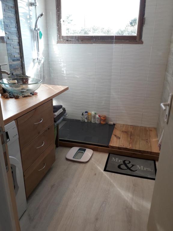 La salle de bains est pourvue d'un comptoir, d'un lavabo et d'une fenêtre. dans l'établissement Grand appartement avec jardin Promos en juillet location a la semaine samedi au samedi ou dimanche au dimanche, à Soulac-sur-Mer